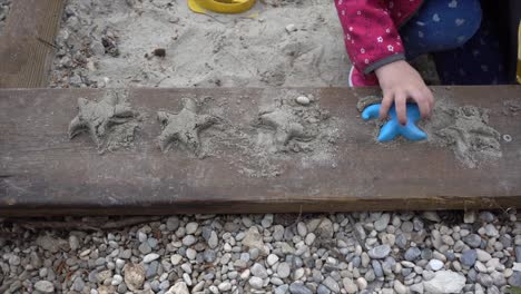 young girl makes some cute starfish in the fine adriatic sand