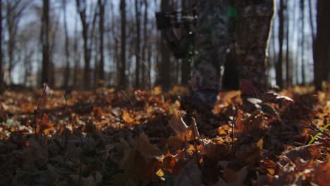 bow hunter walks through woods during hunting season