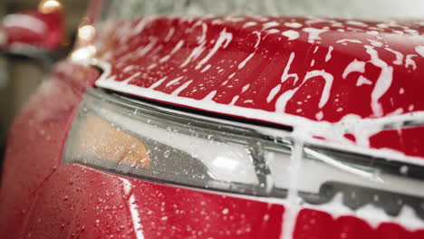 red car undergoing foam wash