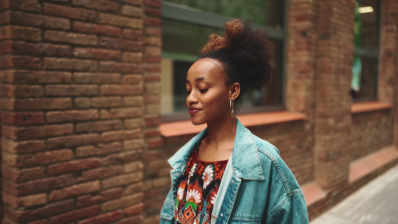 Stylish woman in denim jacket on city street