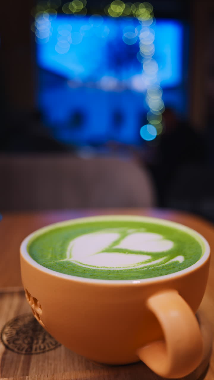 Close up of a matcha latte on a wooden tray at a cafe. Vertical