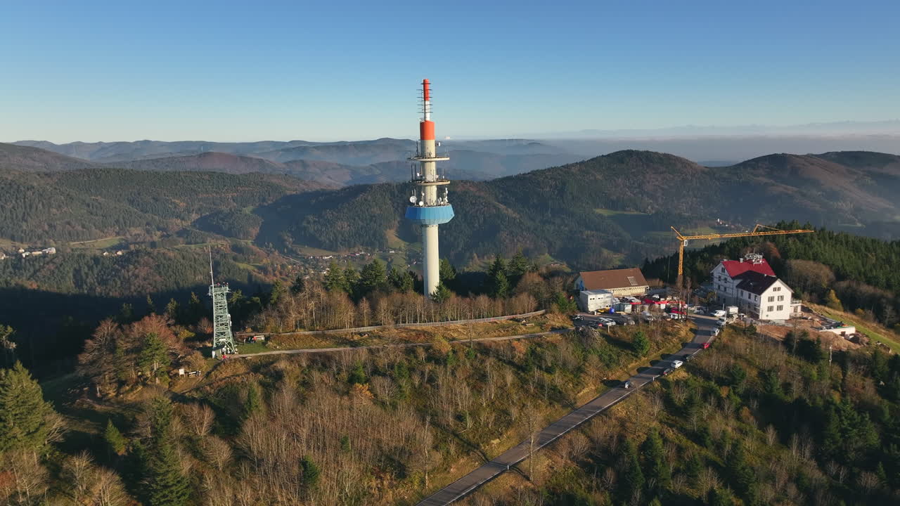 Broadcast tower on top Blauen Peak with surrounding forested hills under a clear blue sky
