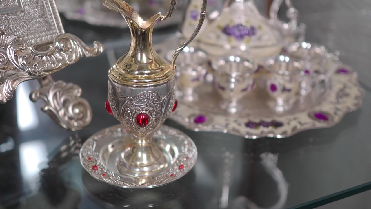 Ornate Silver Pitcher and Tea Set with Red Gemstones