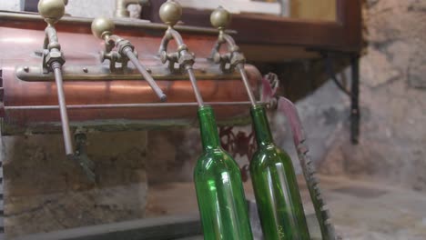 antigua máquina de llenado de botellas de vino con dos botellas adjuntas
