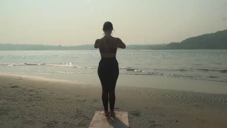 yoga de pose de adoración al sol en la playa dorada de la luz del sol, estilo de vida saludable surya namaskara