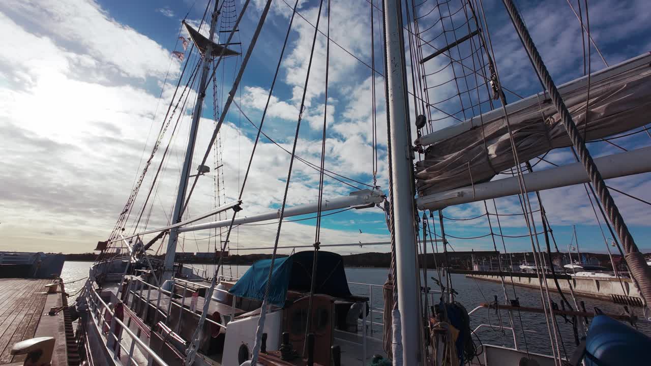 A sailing ship anchored in a dock with a picturesque sky on the horizon