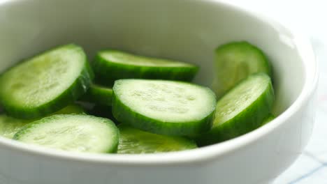 sliced cucumbers in a white bowl