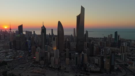 breathtaking 4k drone shot of kuwait city at sunrise. towers glow under golden skies with the calm gulf in the background. ideal for cinematic, travel, or architectural footage.