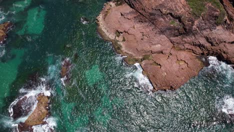clear blue sea and rugged foreshore of anna bay in new south wales, australia. aerial tilt-up shot