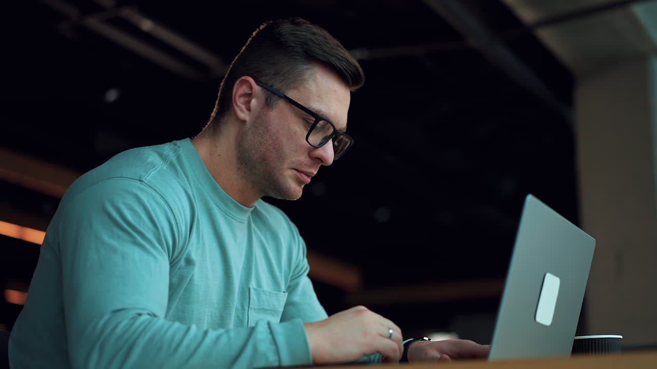hombre trabajando en una computadora portátil en un café
