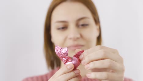 woman eating chocolate with heart in close-up. eating chocolate.