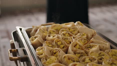 Steaming-Hot-Platter-of-Breakfast-Burritos-in-Metal-Dish