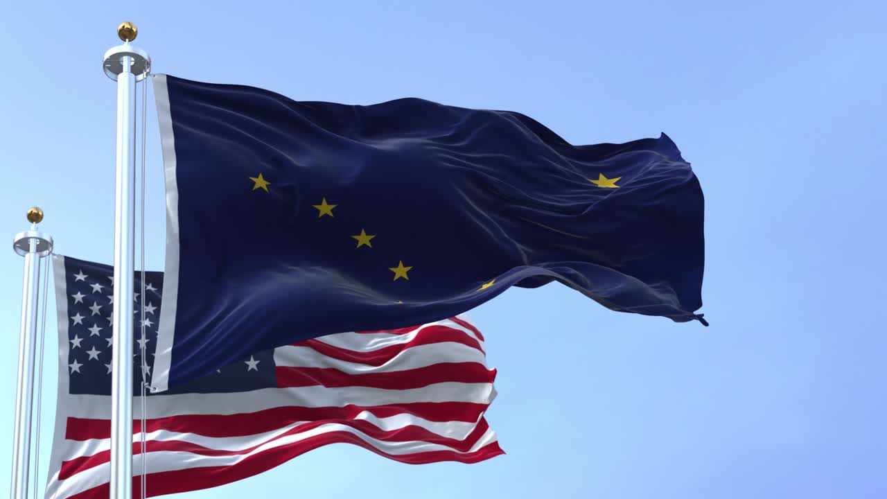 Le bandiere dello stato dell'Alaska e degli Stati Uniti che sventolano al vento.