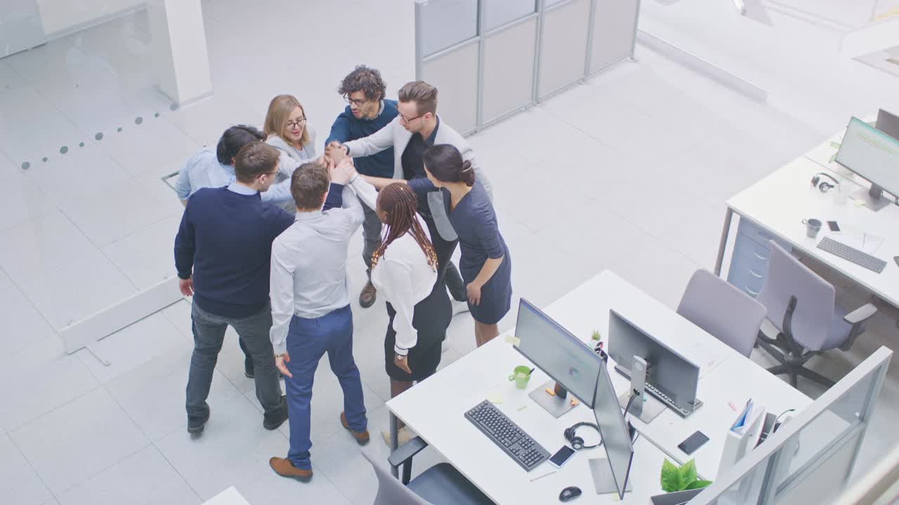trabajadores de oficina haciendo ejercicio de team building apilando las manos juntos en el espíritu unificador de la creatividad y la causa común. ocho personas exitosas aplaudiendo juntos a un nuevo comienzo. fotografía de ángulo alto en un moderno edificio de oficinas brillante