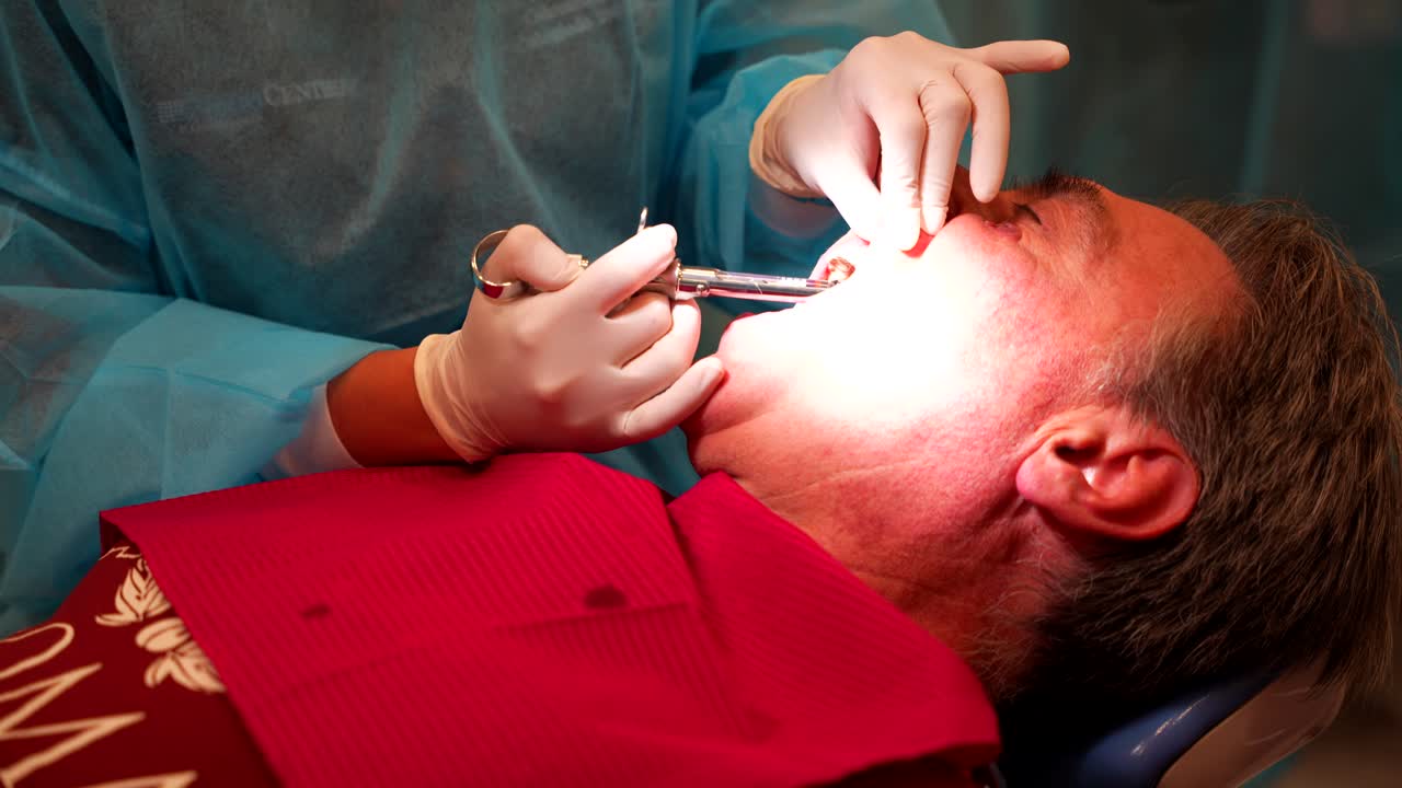 Dentista che inietta anestesia nella bocca del paziente.
