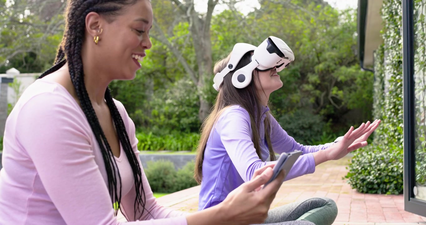African American coach guiding VR user wearing headset after tapping tablet swiping panels on patio