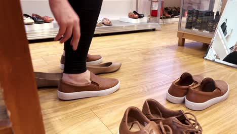 lady in a shoe shop trying new pairs of comfortable shoes, sneakers