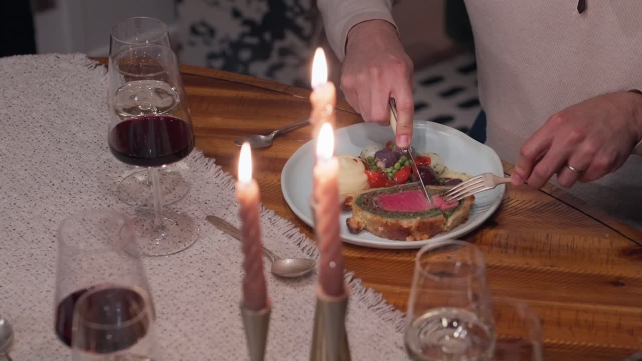 Una cena rustica a base di Beef Wellington viene gustata al tavolo di un'esperienza culinaria privata (slow motion 4K).