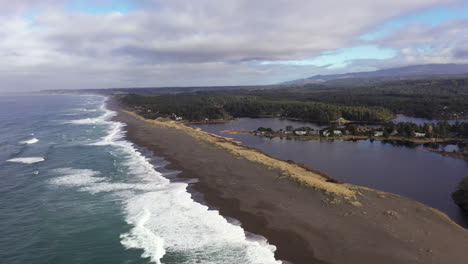 garrison lake in port orford at the southern oregon coast, divided from the ocean by a thin strip of beach, drone shot 4k