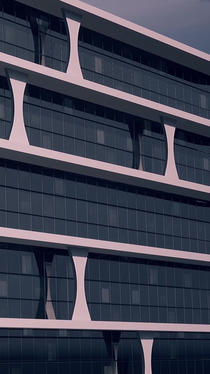 Edifici moderni con design unici in una zona urbana, illuminati dalla luce serale.