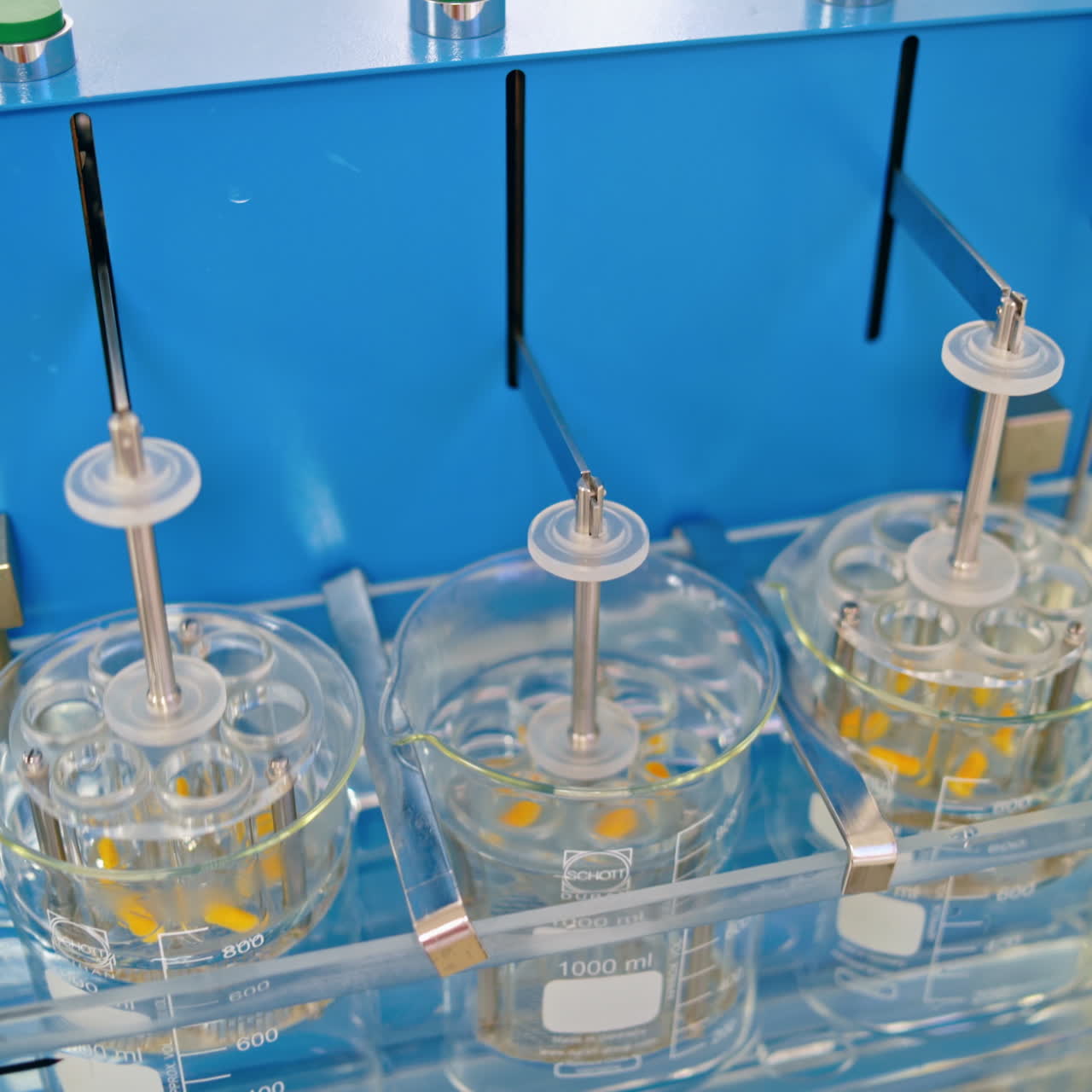 Experiments at the lab. Sliding shot of a dissolution apparatus testing medication pills dissolving tablets in liquid. Laboratory routine.