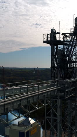 top of industrial plant. modern elevators and metal tower on nature background. smoke goes from large factory in the countryside. aerial view. vertical video