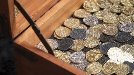 sideview of gold coins hitting a treasure chest