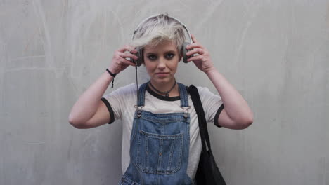 portrait cute young woman puts on earphones enjoying listening to music wearing stylish fashion confident female student urban youth