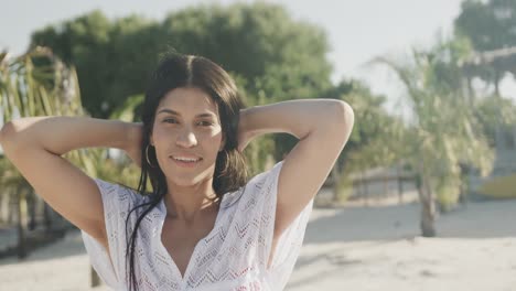 retrato de una feliz mujer hispana bailando en una playa soleada, sonriendo, en cámara lenta