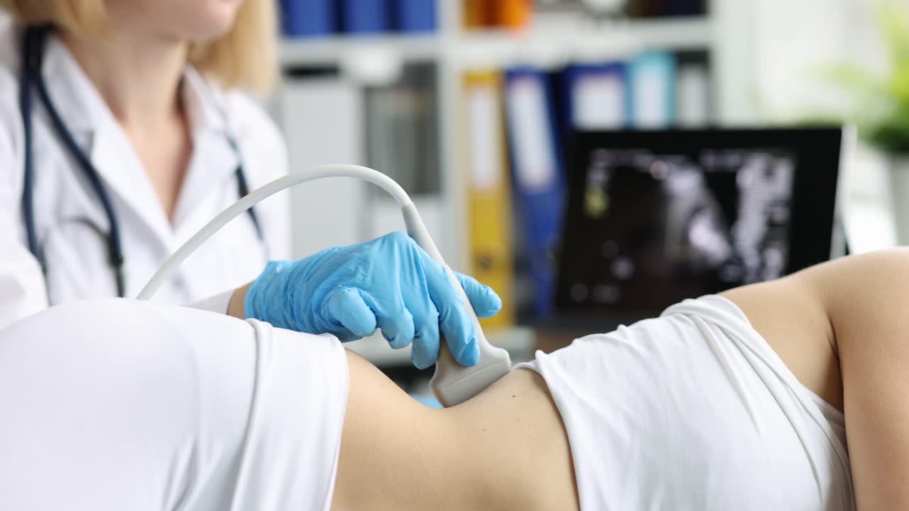 Female doctor examines patient kidneys with ultrasound scan