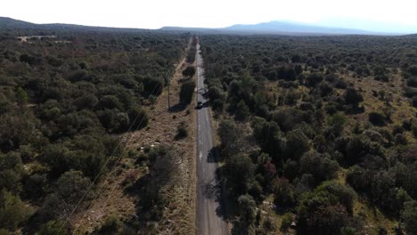 Toma-Aérea-De-Seguimiento-De-Un-Vehículo-Que-Viaja-Por-Una-Carretera-En-Un-Valle-En-Francia.