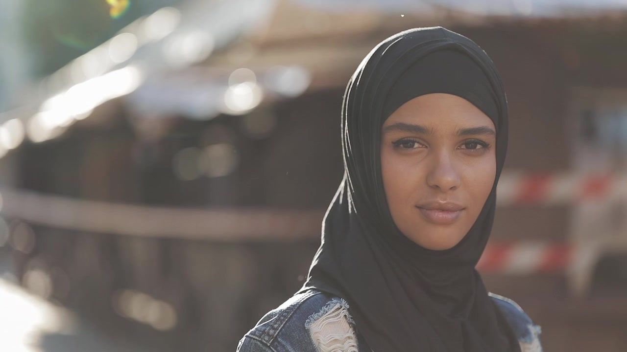 Portræt af en ung kvinde iført sort hijab udendørs