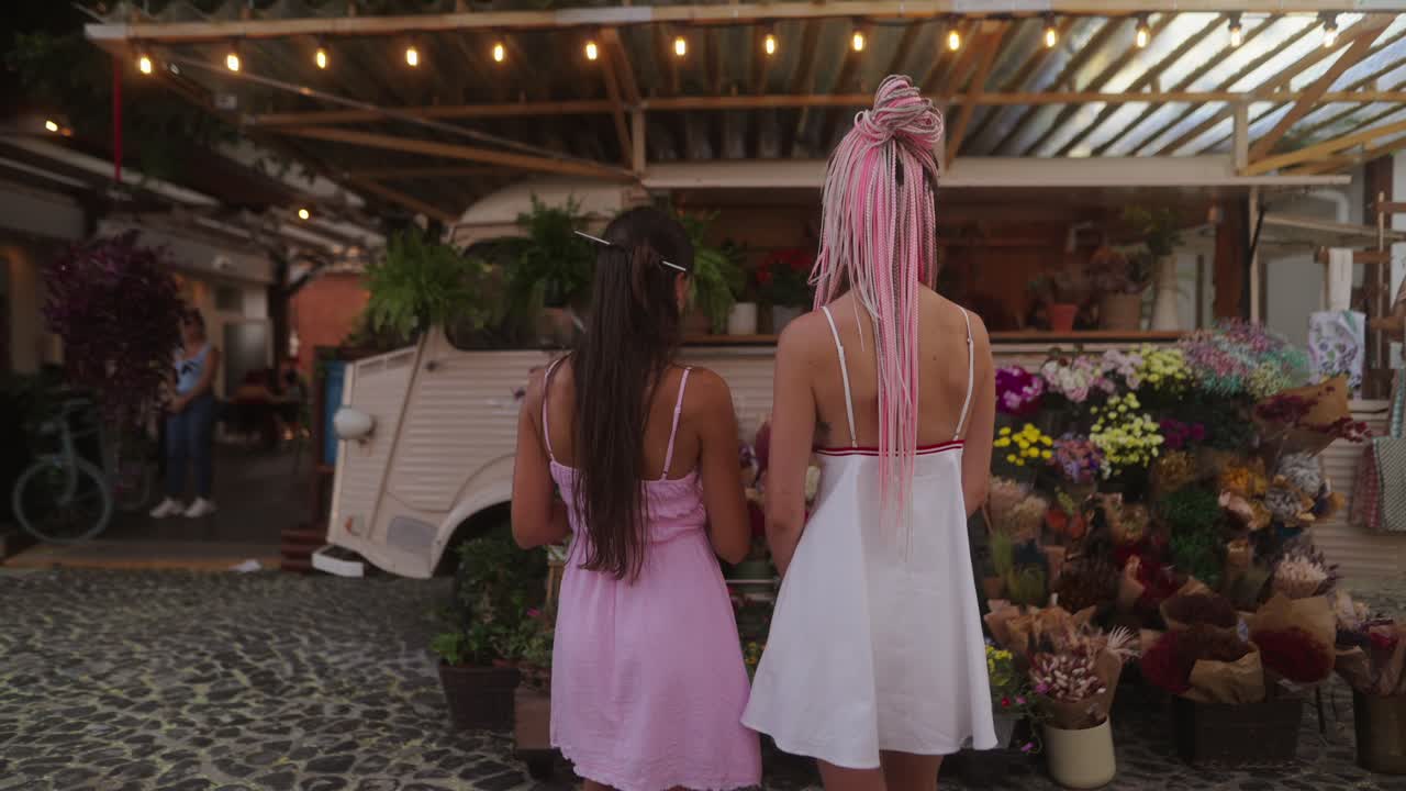 Two women in front of a flower truck