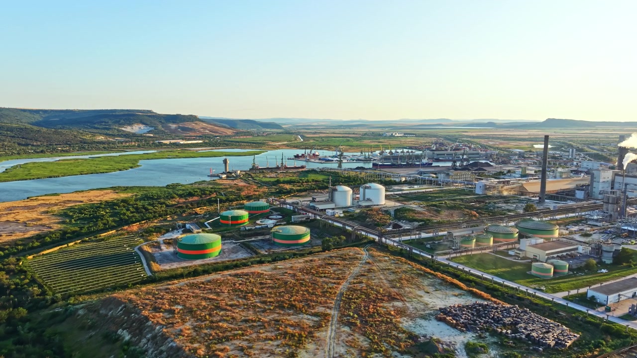Industrial area near river with storage tanks and factories during daytime
