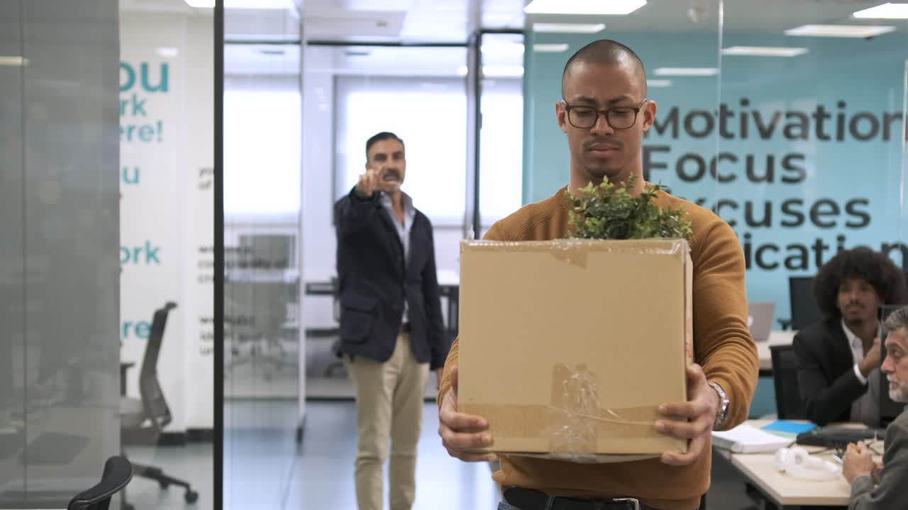 Male boss firing employee in office