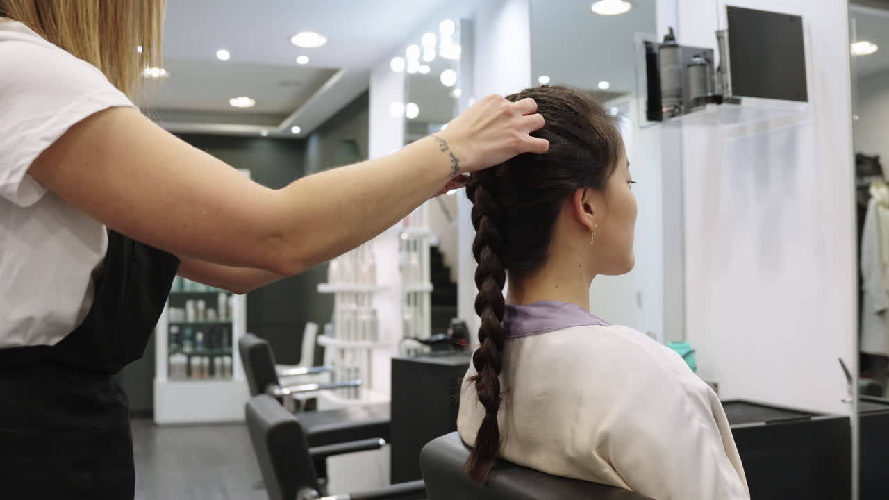 Woman getting her hair braided at a salon