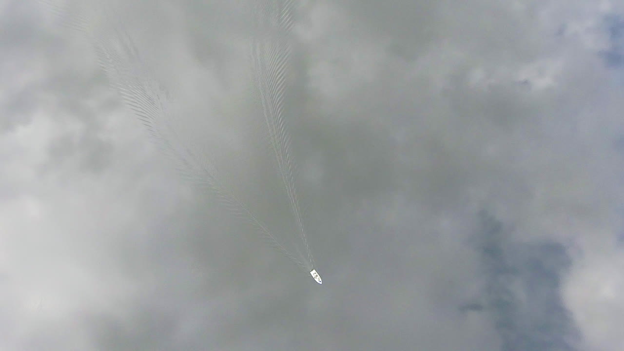 핀란드의 평온한 호수와 같은 거울에 작은 배를 타고 트롤링하는 어부들의 몽환적인 드론 영상