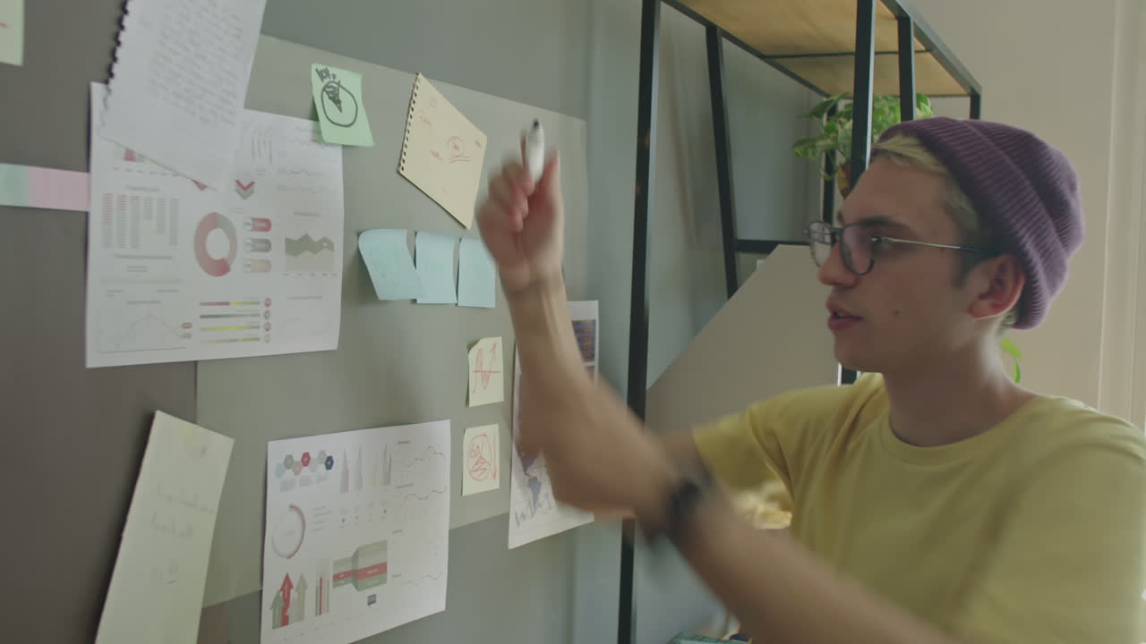 Gen Z Man Writing Notes on Office Wall and Giving Business Presentation