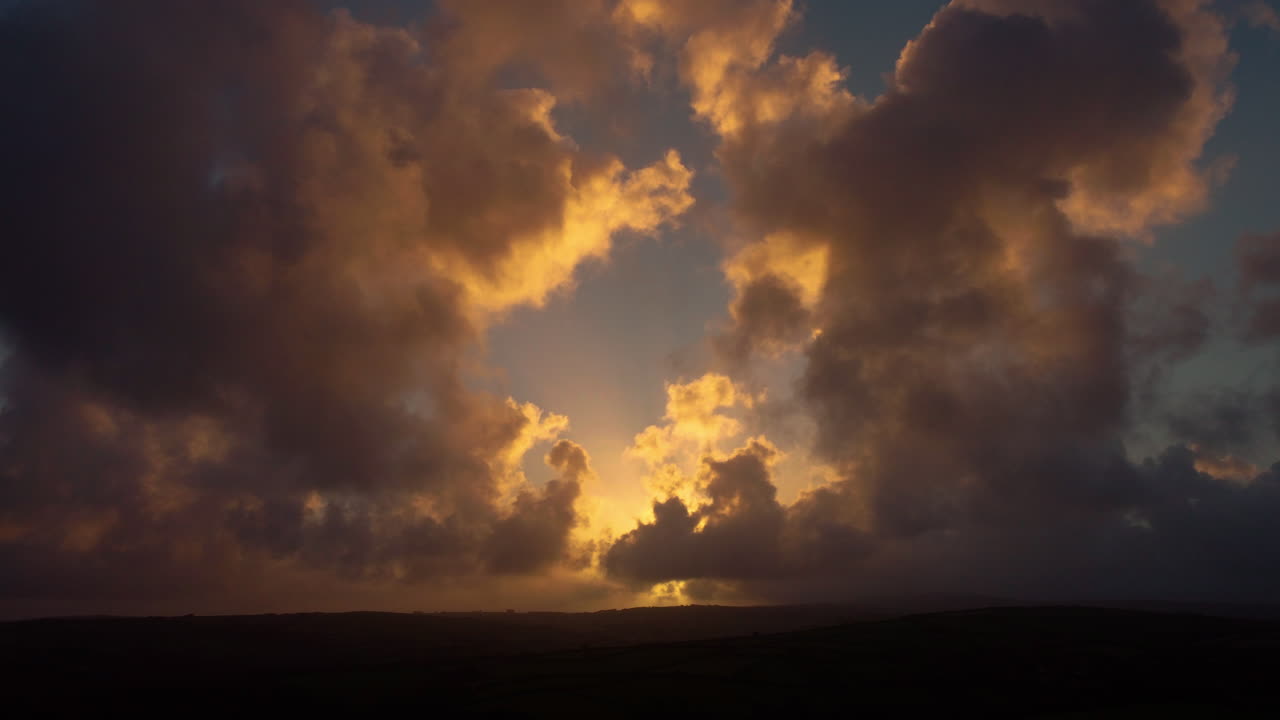 Sunrise Dawn Timelapse with Sun Rising and Godrays Light Piercing Through Dark Clouds across Hills Landscape on Exmoor England UK 4K