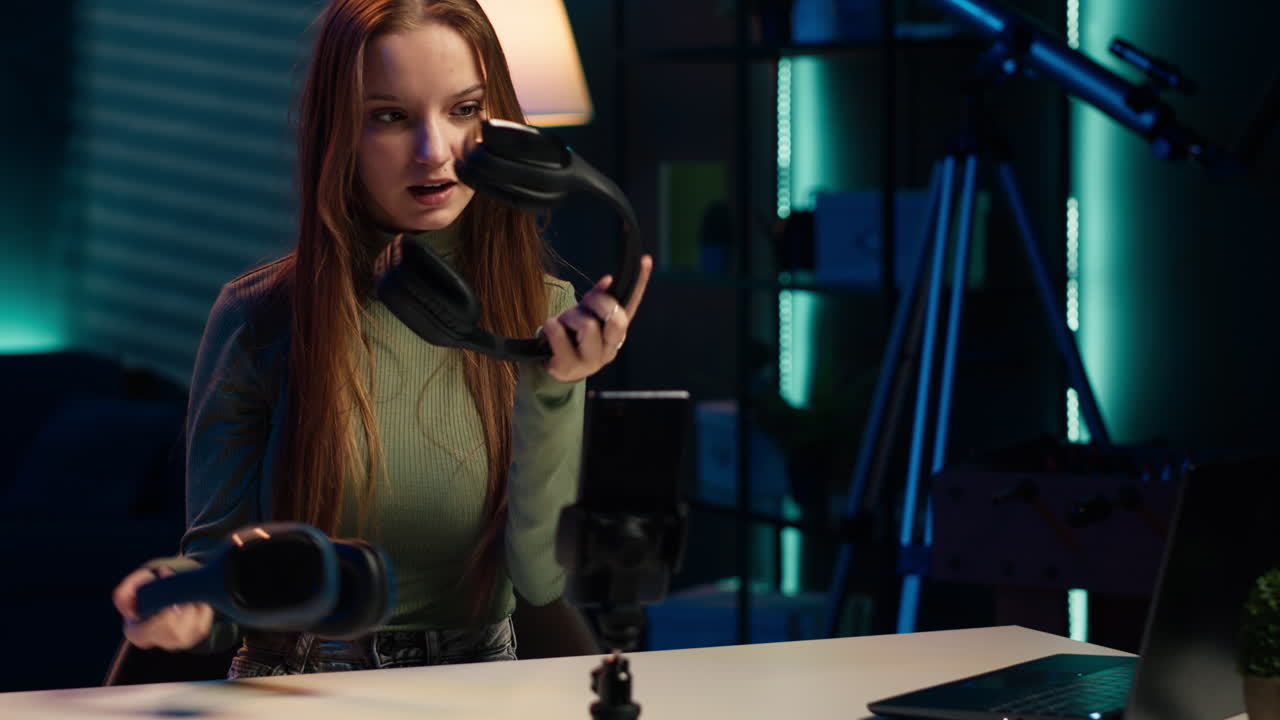 인터넷 쇼 호스트가 값비싼 헤드폰을 손에 들고 선물을 하고 있습니다.