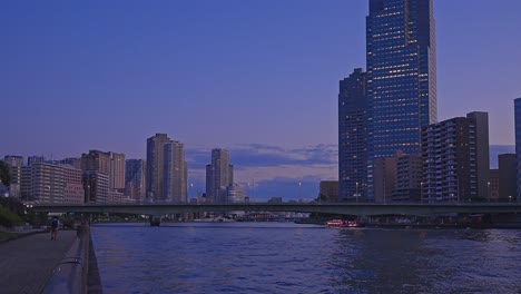 por la noche, los rascacielos de tokio, tsukuda, toyosu y el puente del río sumida