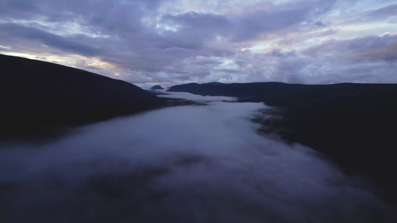 Dramatic cloudscape in blue hour, drone moving above fog