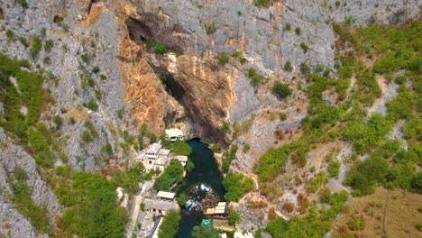 rural settlement with towering rocky cliffs at blagaj village in bosnia and herzegovina