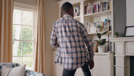 happy african american man dancing at home celebrating success having fun crazy dance in living room enjoying lifestyle freedom on weekend 4k