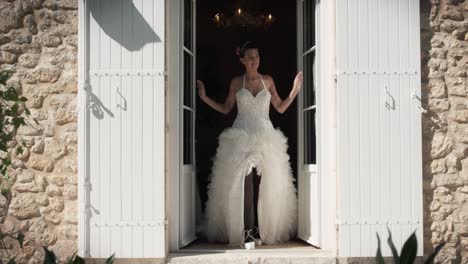 slow motion shot of a bride exiting the building in her beautiful white lace dress