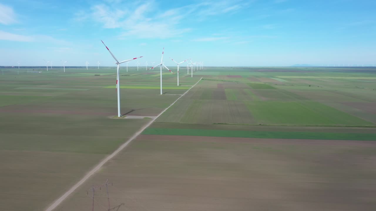 View of several windmills, wind generators, turbines, producing renewable clean energy by converting kinetic energy