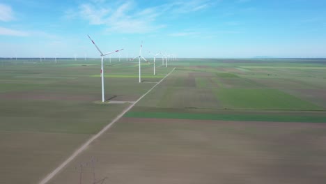 view of several windmills, wind generators, turbines, producing renewable clean energy by converting kinetic energy