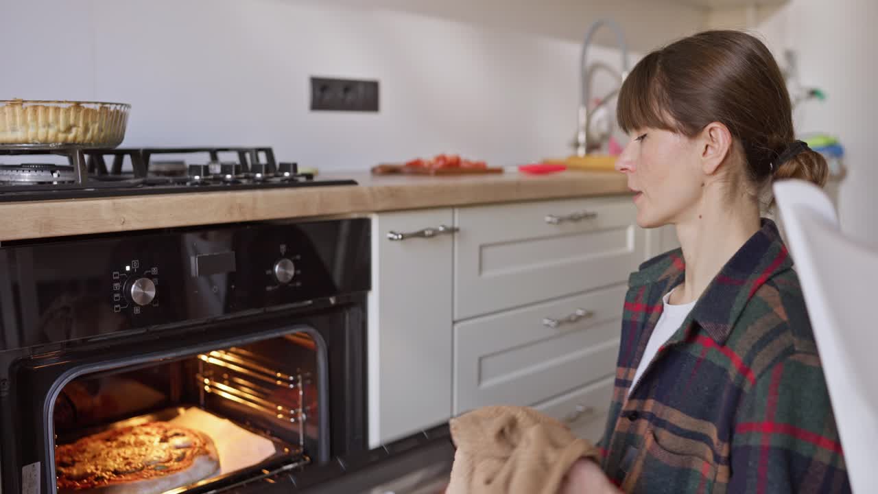 Donna che cucina la pizza in cucina