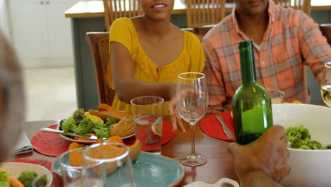 Vista-Frontal-De-Una-Familia-Negra-Comiendo-En-La-Mesa-Del-Comedor-En-Una-Casa-Cómoda-4k