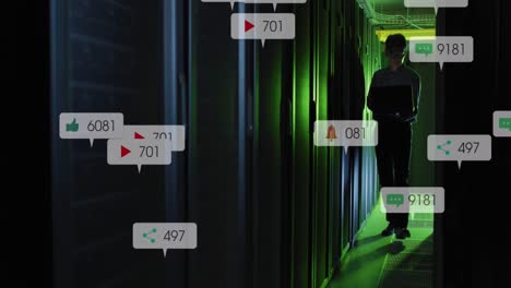 animación de iconos de redes sociales sobre ingeniero masculino asiático usando portátil en la sala de servidores.